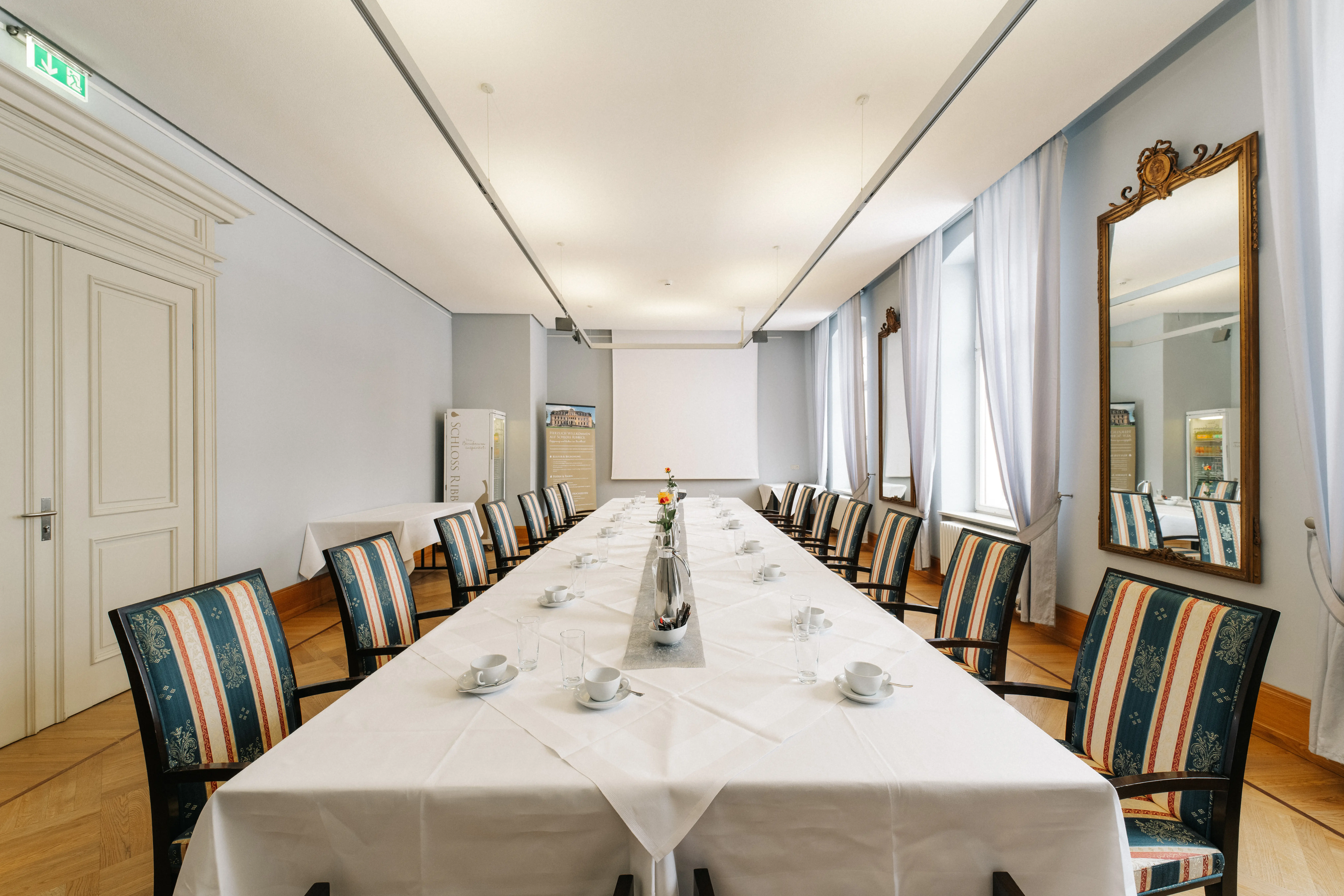 Tagungsraum auf Schloss Ribbeck mit gedeckten Tischen und Pausenbereich